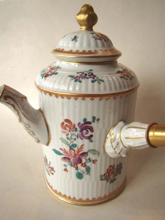 A French porcelain 'armorial' style chocolate pot with side mounted fruitwood handle